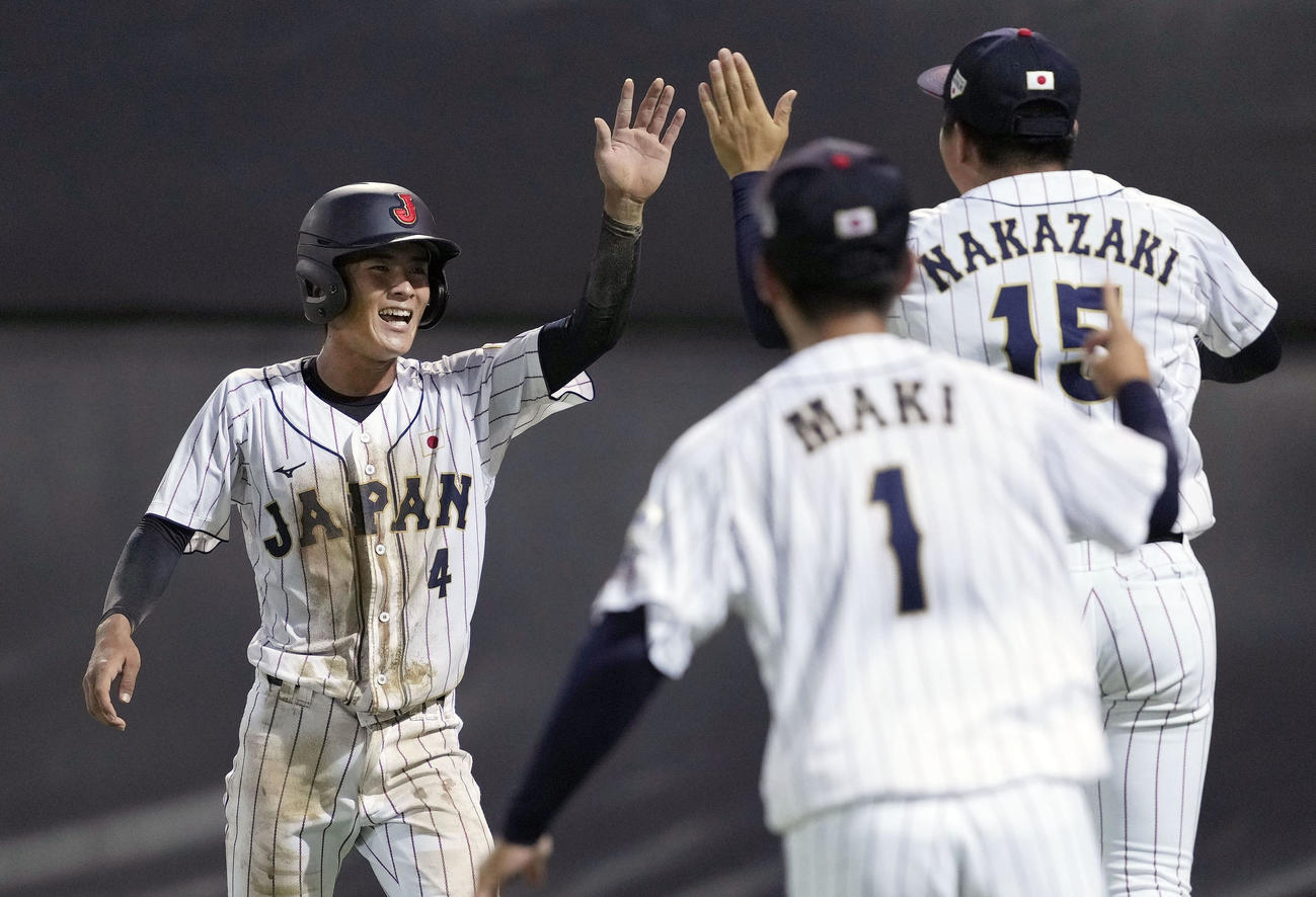 台湾戦の6回、先制の生還をし、タッチを交わす山畑（共同）