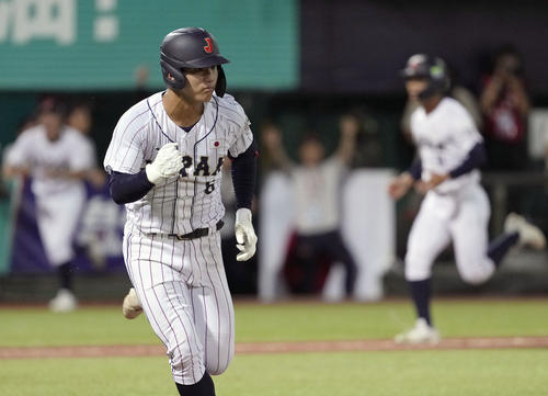 台湾戦の1回、先制打を放ち、ガッツポーズで一塁へ向かう石塚（共同）