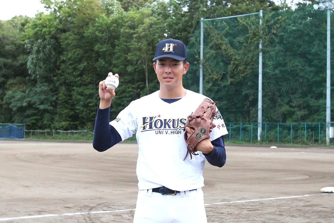 北星学園大付高の石田投手は、自校のグラウンドで笑顔を見せる（撮影・中島洋尚）