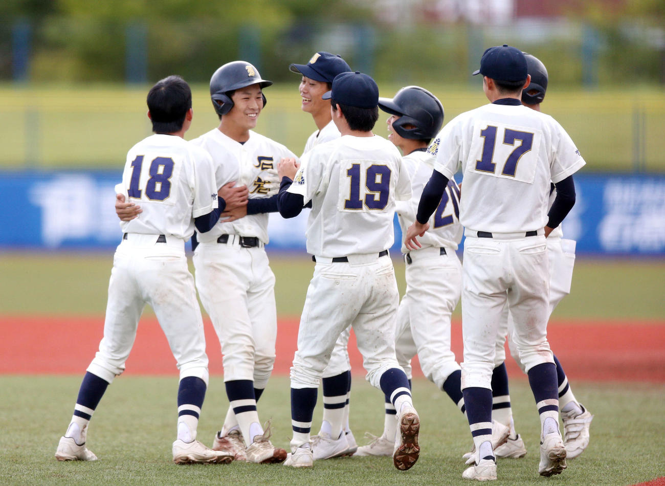角田対石巻　9回裏石巻2死二塁で左越え適時二塁打でサヨナラ勝利を決め、ナインらに祝福される石巻・斎藤（左から2人目）（撮影・木村有優）