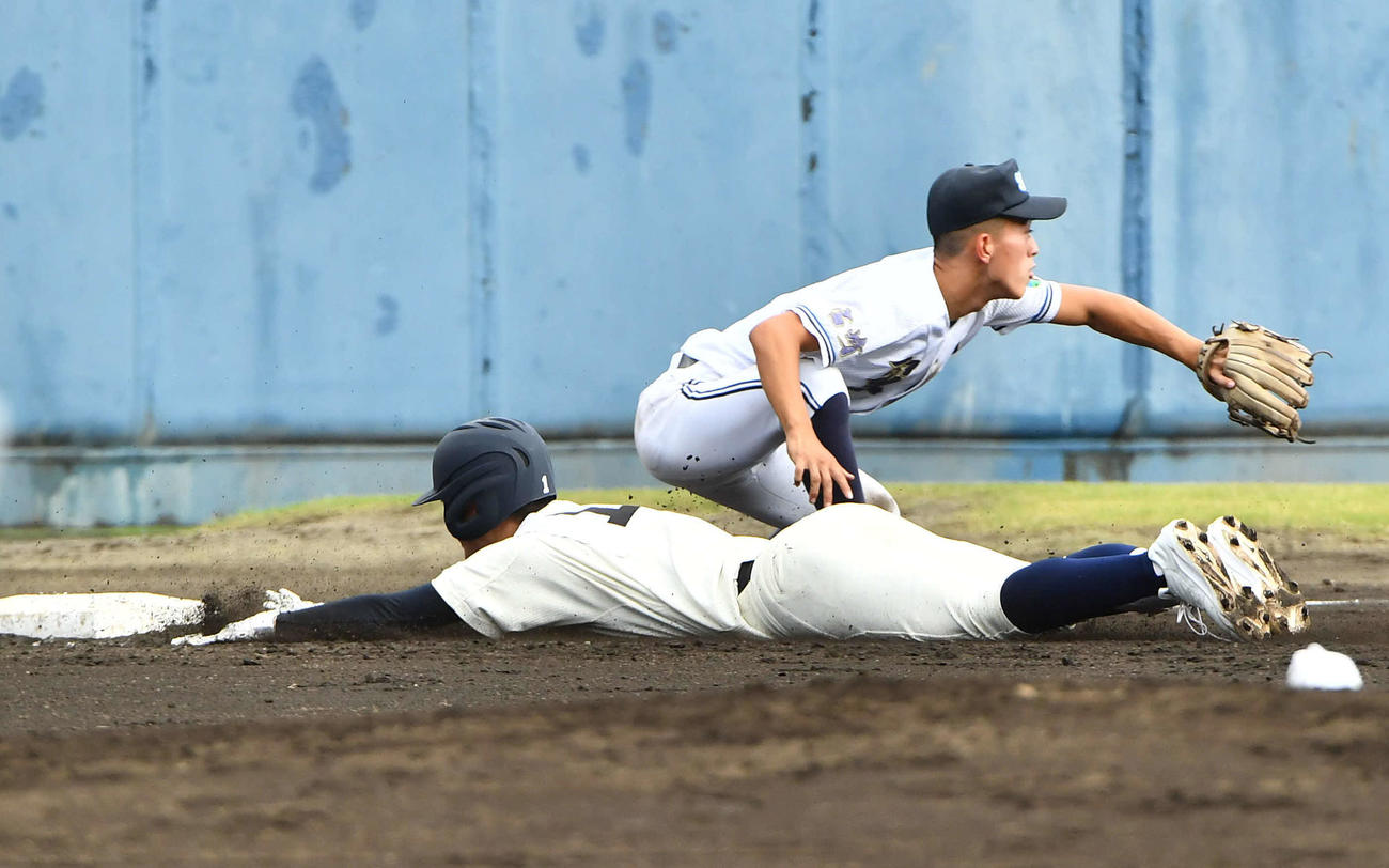 西日本短大付対聖心ウルスラ　2回表西日本短大付1死満塁、先制の左越え3点適時三塁打でヘッドスライディングする中野（撮影・岩下翔太）