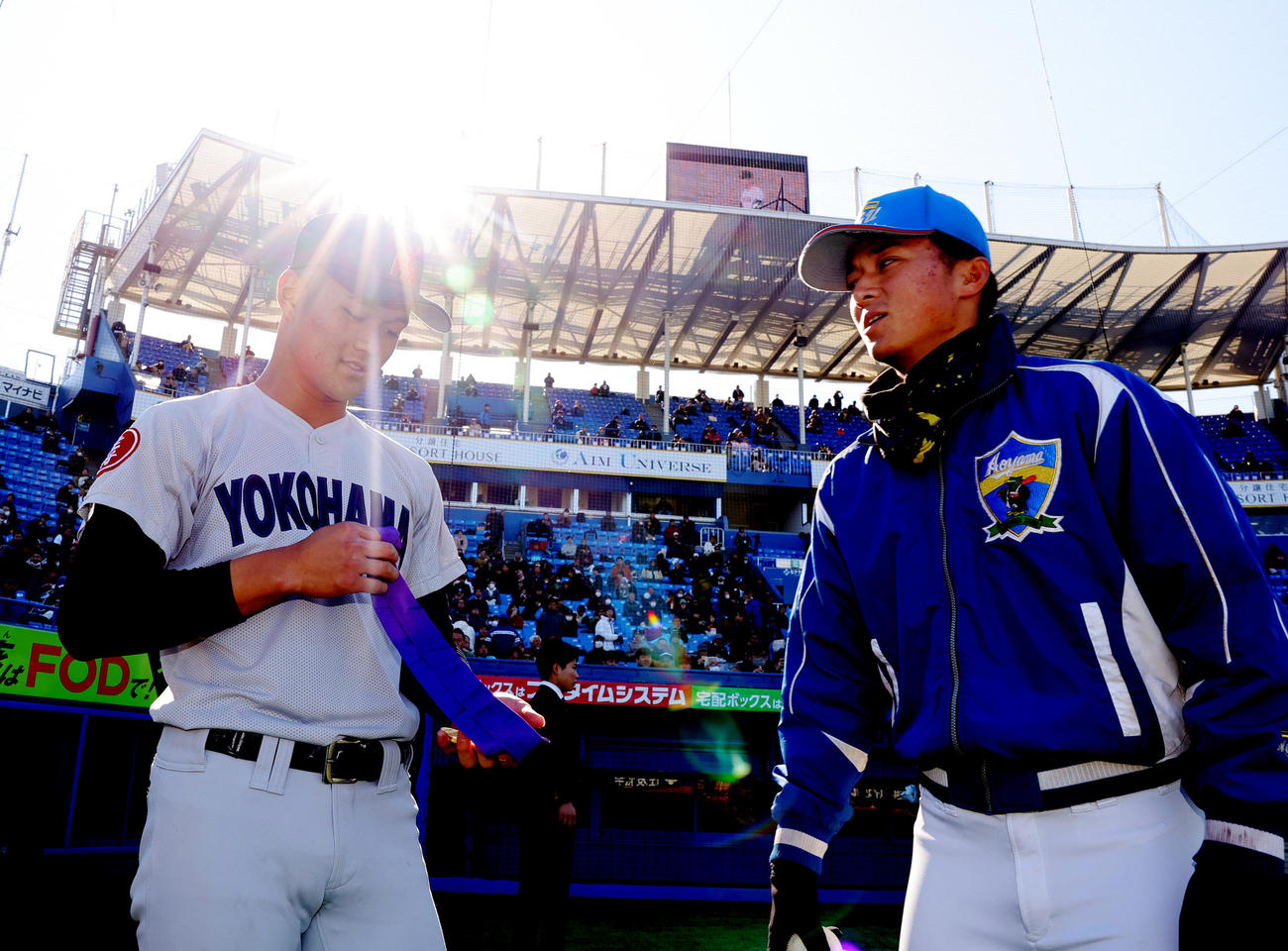 広島商対横浜　優勝した横浜・阿部葉主将（左）は、次の試合で球場入りした青学大・佐々木主将から祝福される（撮影・野上伸悟）