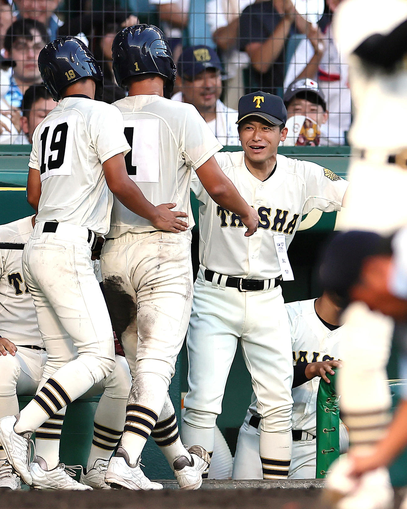 スクイズで生還した馬庭（中央）を笑顔で迎える石飛監督（2024年8月撮影）