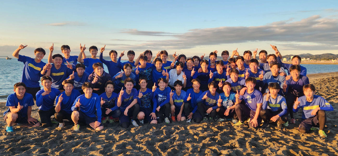 中央学院・砂浜でのトレーニングを終え、笑顔で1番ポーズを見せる中央学院の野手たち（撮影・保坂淑子）