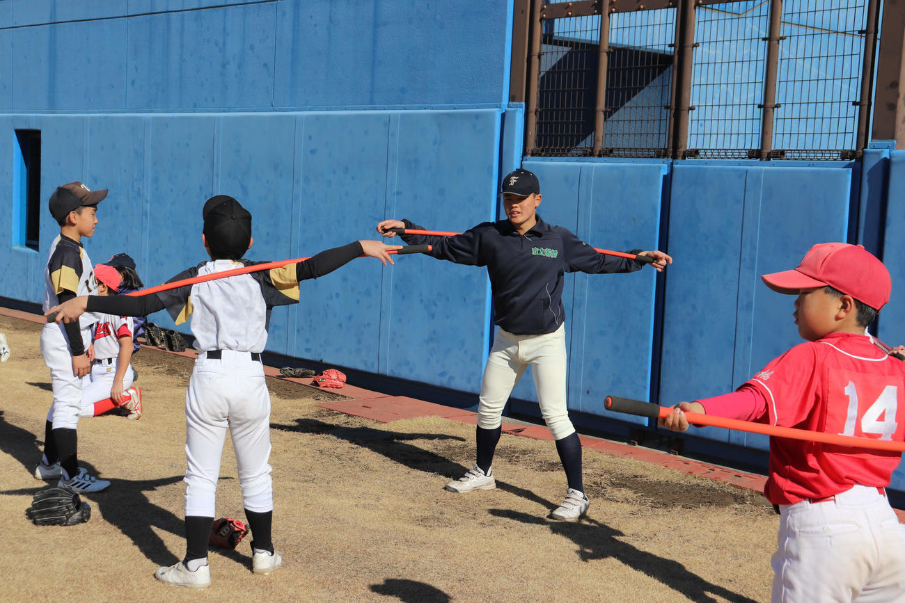 第3回いちふなスポーツフェスタで、小学生に投手のトレーニング方法を指導する野球部の選手（撮影・保坂淑子）