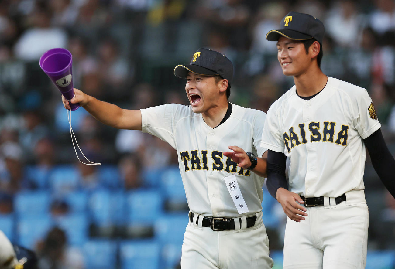 24年8月全国高校野球選手権　第11日　早実対大社　10回表の守備を終えたナインを迎える大社・石飛監督（左）
