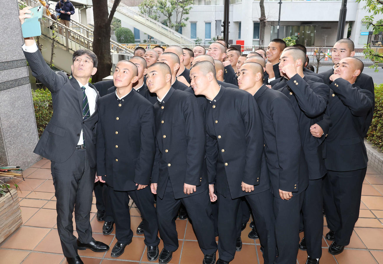 センバツ出場を決めた二松学舎大付の選手たちと自撮りをする鵜飼校長（撮影・宮地輝）