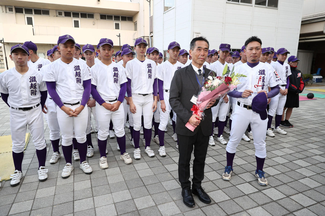 春夏通じて初の甲子園出場が決まった滋賀短大付の保木監督（右）と小林校長はお祝いの花束を受け取る（撮影・西尾就之）
