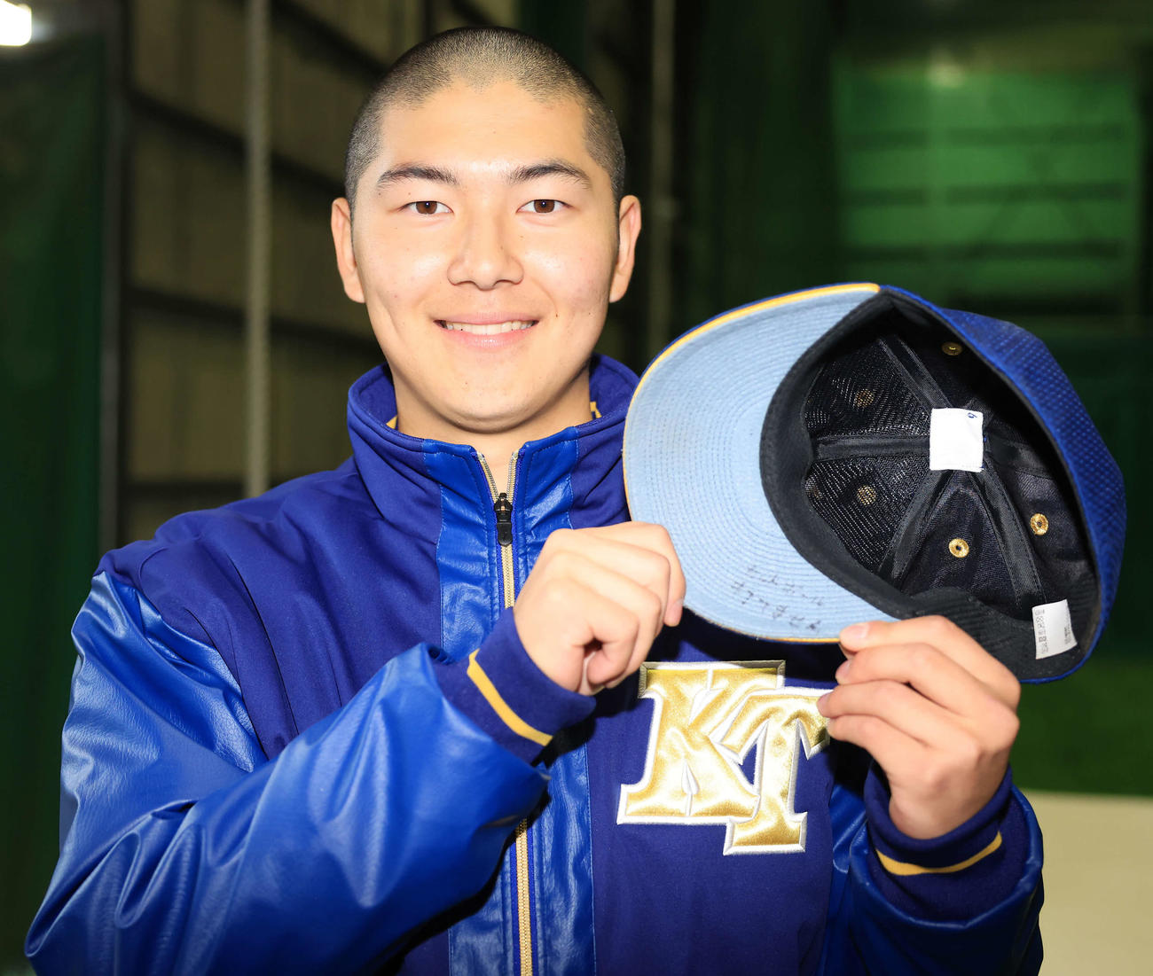 センバツ出場を決め、チームメートから佐藤が投げる「カットボール打てません」と書かれた帽子を見せる健大高崎の佐藤（撮影・浅見桂子）