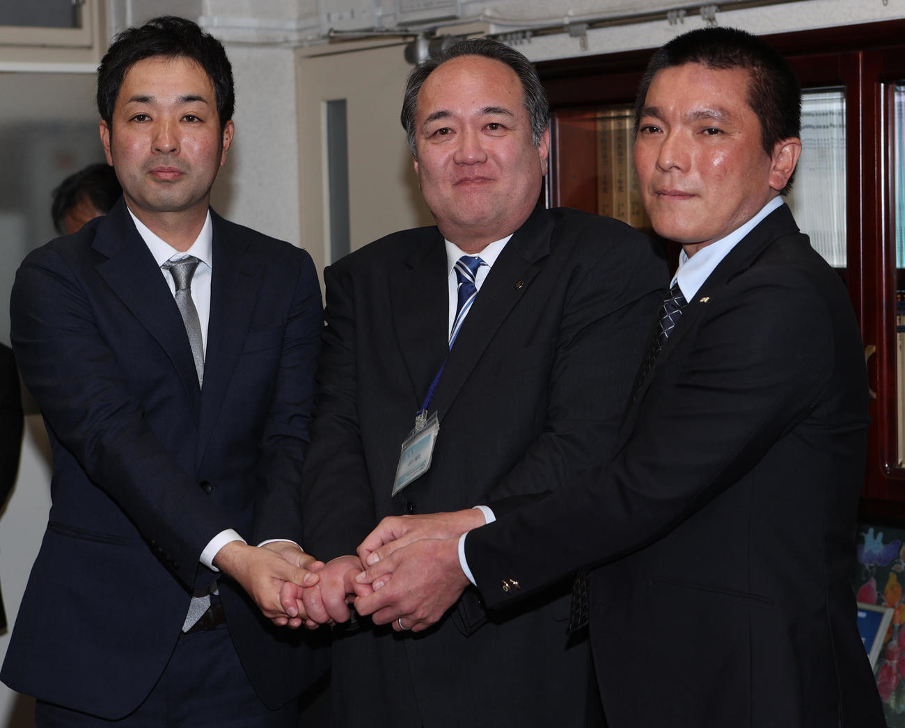 21世紀枠でセンバツ出場が決定し握手する左から横浜清陵の野原監督、山口校長、佐藤部長（（撮影・水谷安孝）