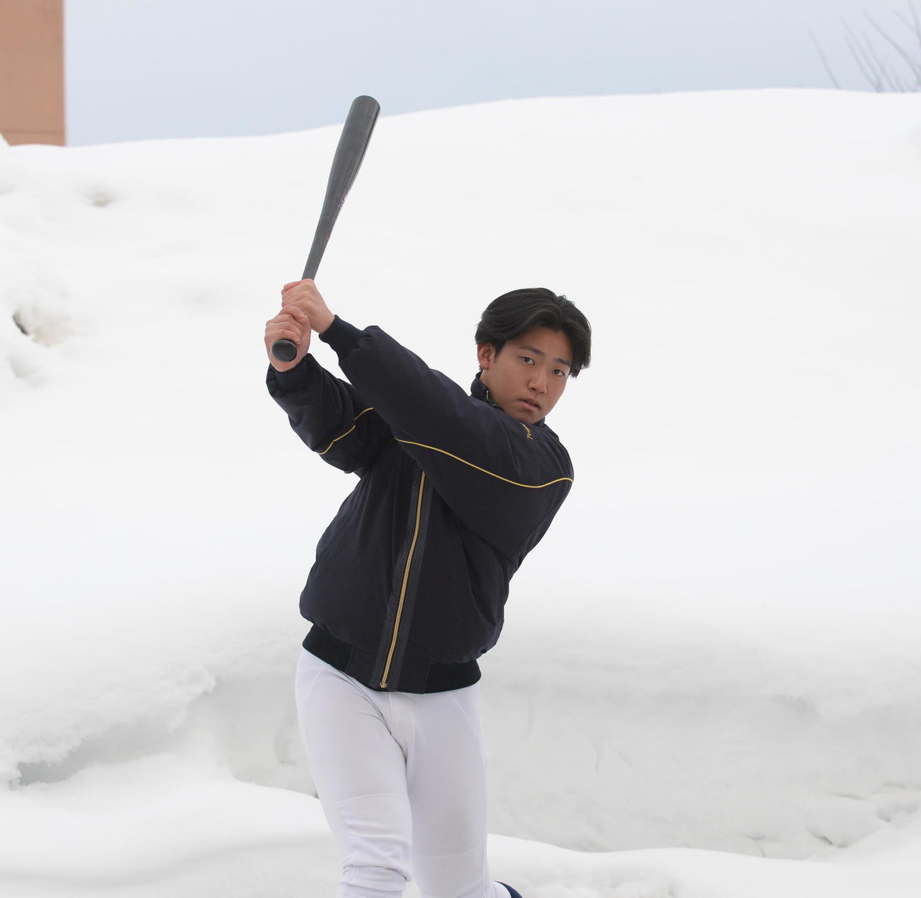 背丈を超える雪を背にバットを振る青森大・八戸（撮影・浜本神威）