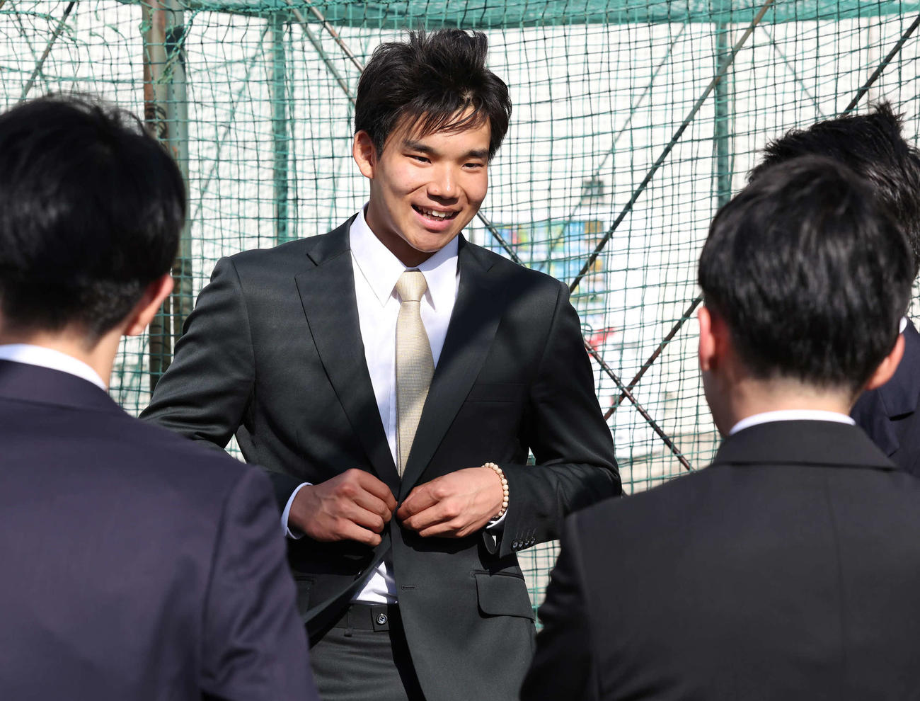 卒業式を終えて同級生たちと談笑する森井（撮影・丹羽敏通）