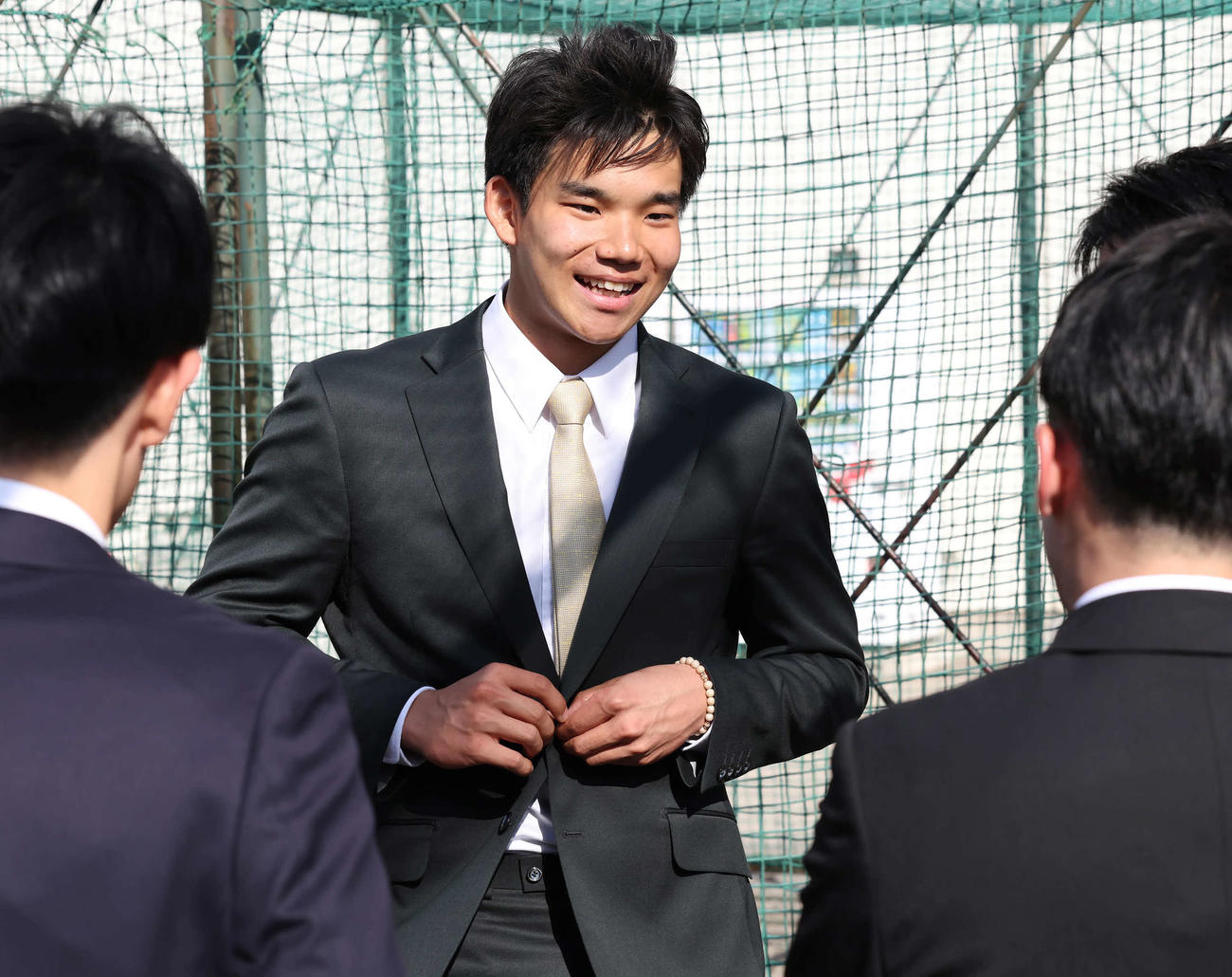 卒業式を終えて同級生たちと談笑する森井（撮影・丹羽敏通）