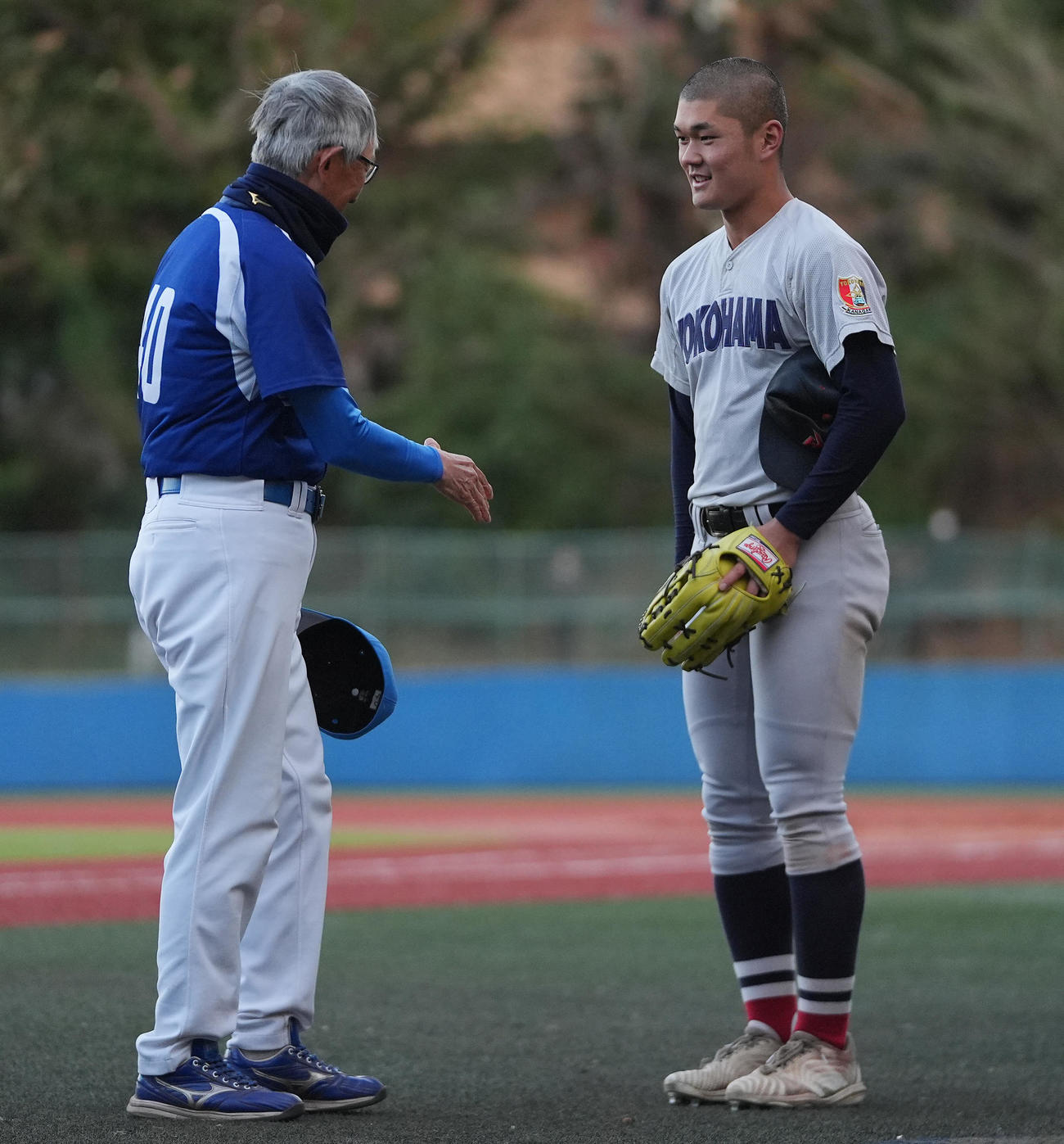 横浜対東大　東大に勝利した横浜・阿部（右）は試合後に東大・大久保監督と握手を交わす（撮影・垰建太）