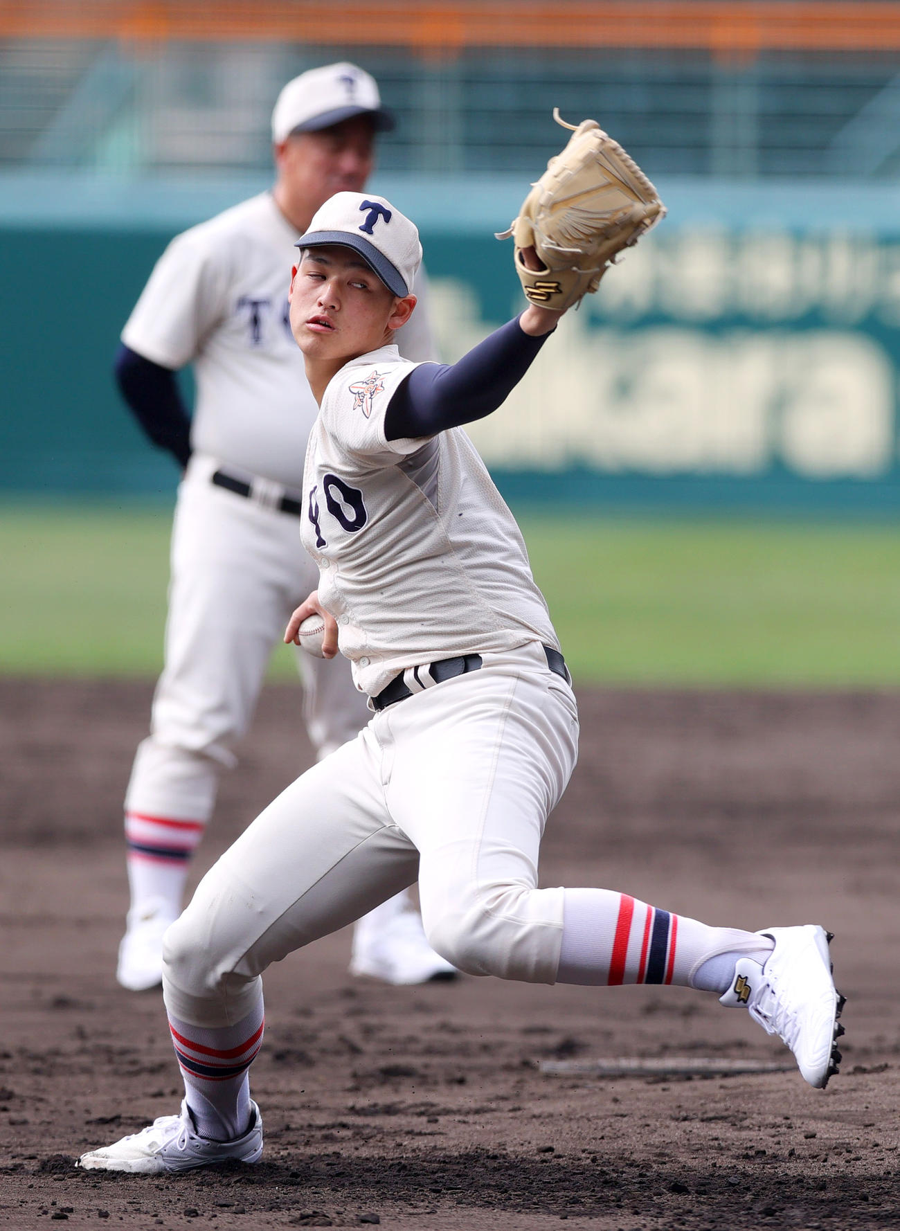 甲子園球場で投球練習をする東洋大姫路・阪下。奥は岡田監督（撮影・上山淳一）