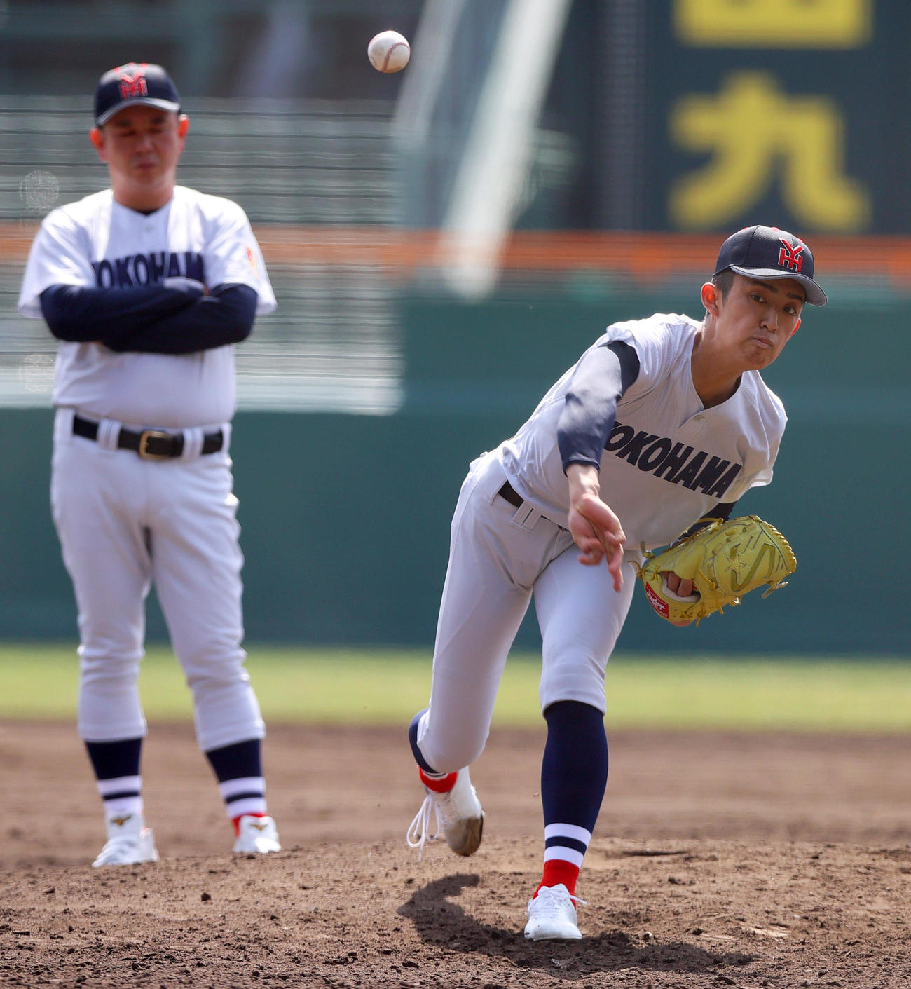 甲子園球場のマウンドで投球練習をする横浜の織田。奥は村田監督（撮影・上山淳一）