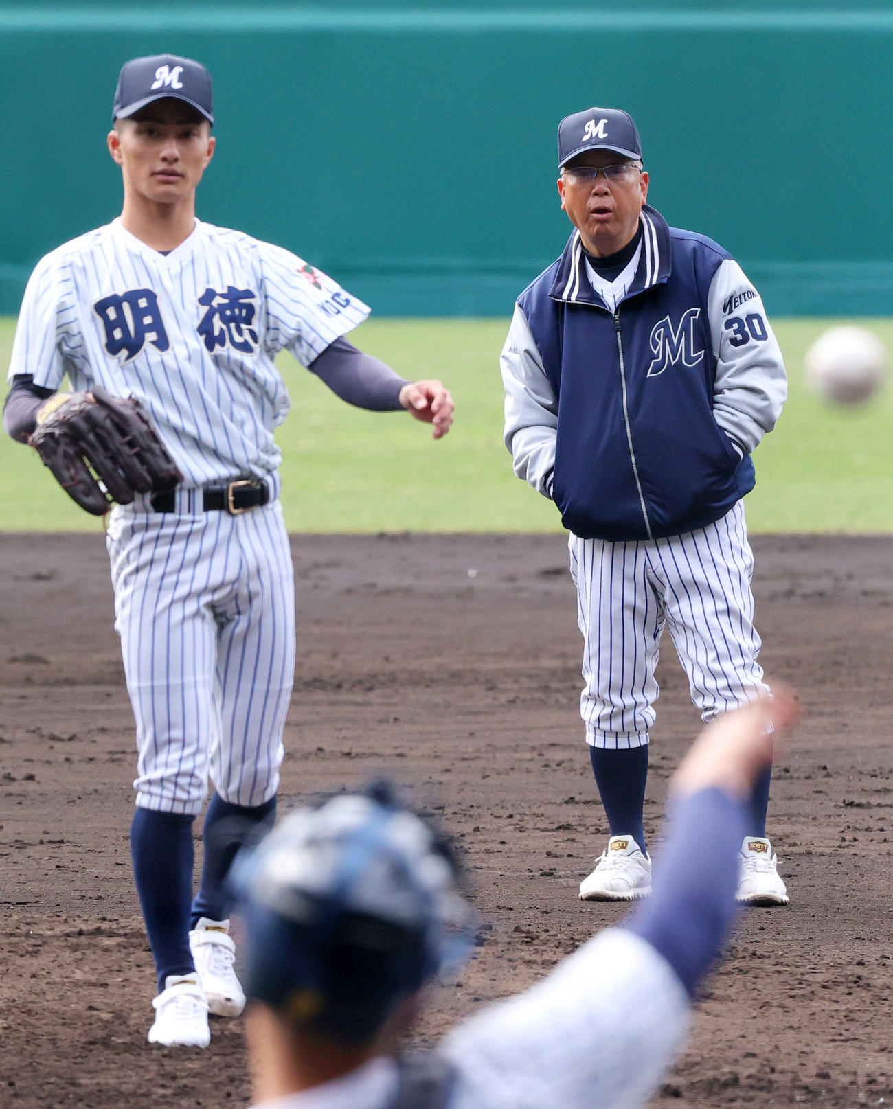 甲子園のマウンドで投球する明徳義塾エース池崎（左）の投球を確認にする馬淵監督（撮影・上山淳一）