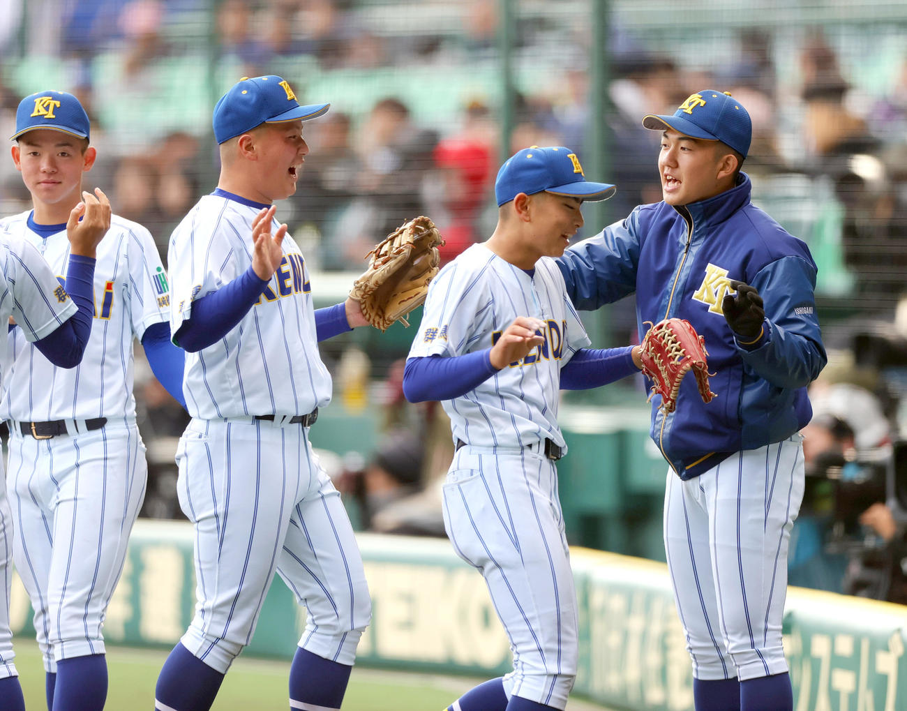 健大高崎対明徳義塾　健大高崎・石垣（右）は初回の守備を終えたナインをベンチ前で出迎える（撮影・上山淳一）