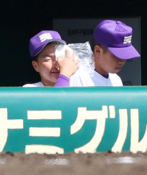 山梨学院対天理　4回裏、ベンチで顔を冷やしながらグラウンドを見つめる天理・石井（左）（撮影・上山淳一）