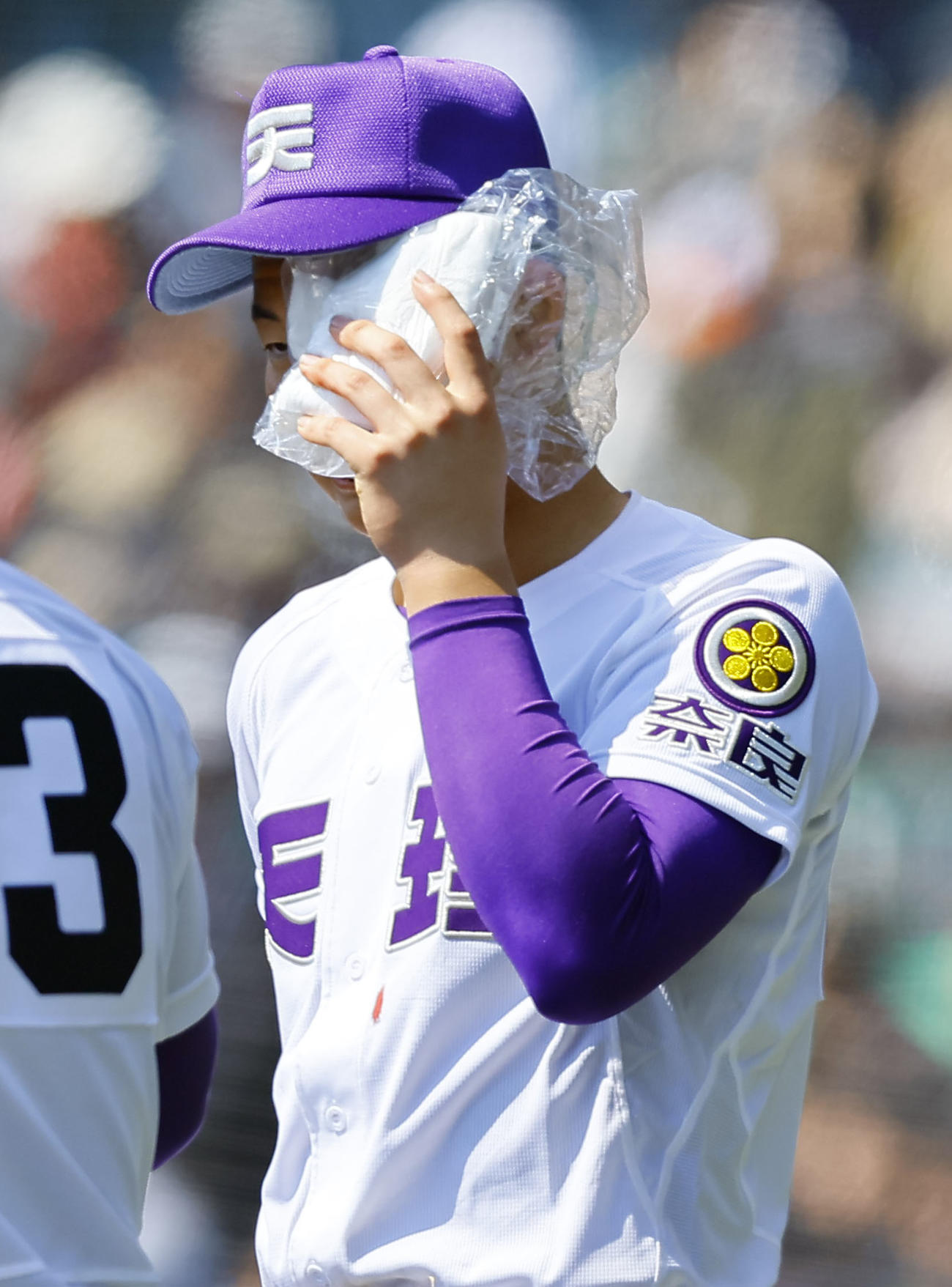 山梨学院対天理　4回、ベンチ前で顔を冷やしながらナインを出迎える天理・石井（撮影・藤尾明華）