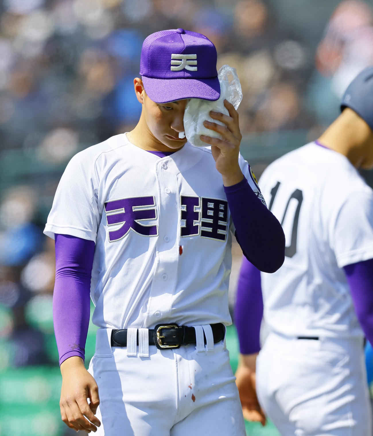 山梨学院対天理　4回、ベンチ前で顔を冷やしながらナインを出迎える天理・石井（撮影・藤尾明華）
