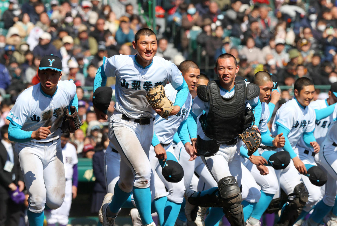山梨学院対天理　天理に勝利し、応援席に向かって笑顔で駆けだす山梨学院ナイン（撮影・上山淳一）