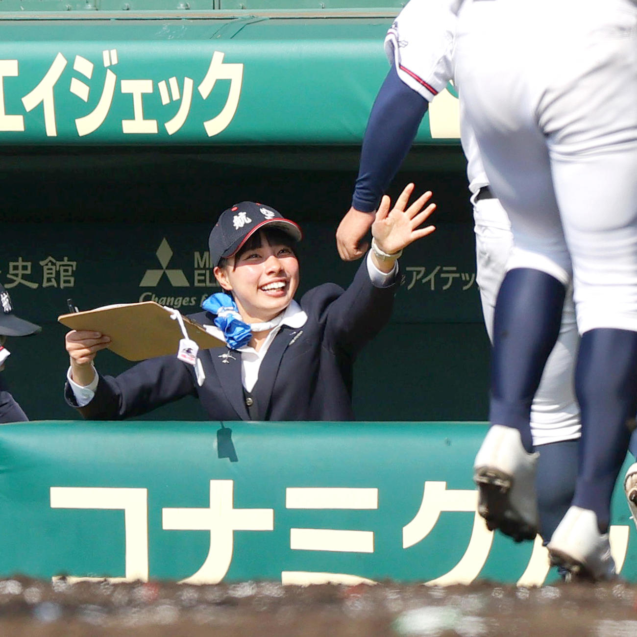 東海大札幌対日本航空石川　2回裏日本航空石川1死満塁、生還した走者を笑顔で出迎える日本航空石川の横田記録員（撮影・上山淳一）