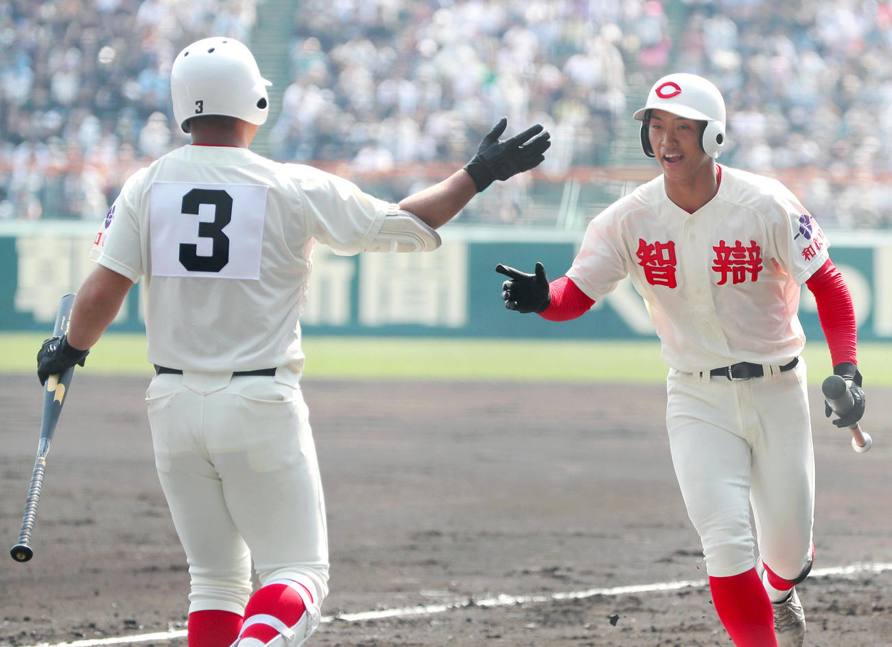 広島商対智弁和歌山　1回裏智弁和歌山1死三塁、三走・山下（右）は福元の右前適時打で生還し次打者・荒井とタッチをかわす（撮影・上山淳一）