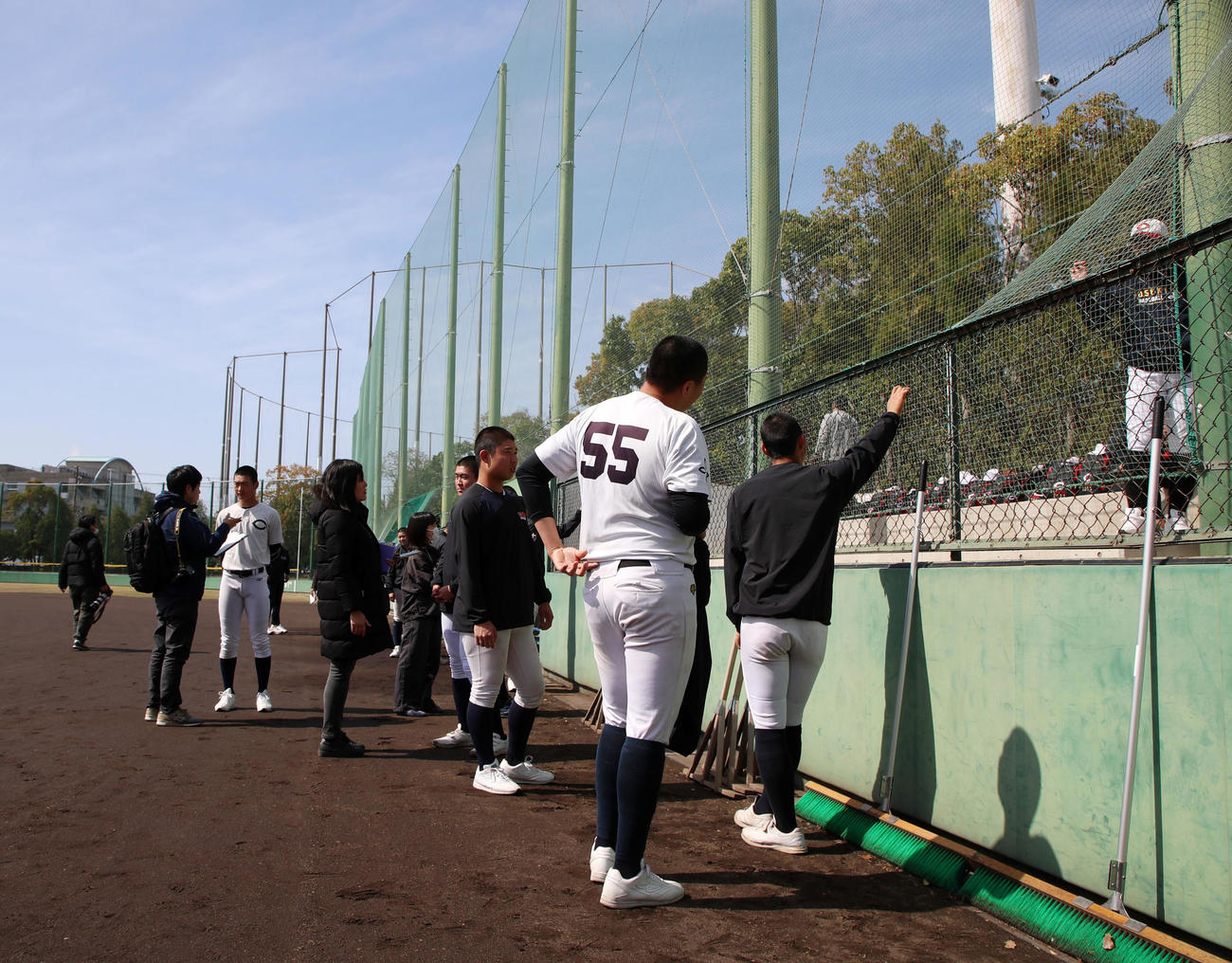 グラウンド状態が悪くフェンス際で思い思いに身体を動かす智弁和歌山ナイン（撮影・加藤哉）