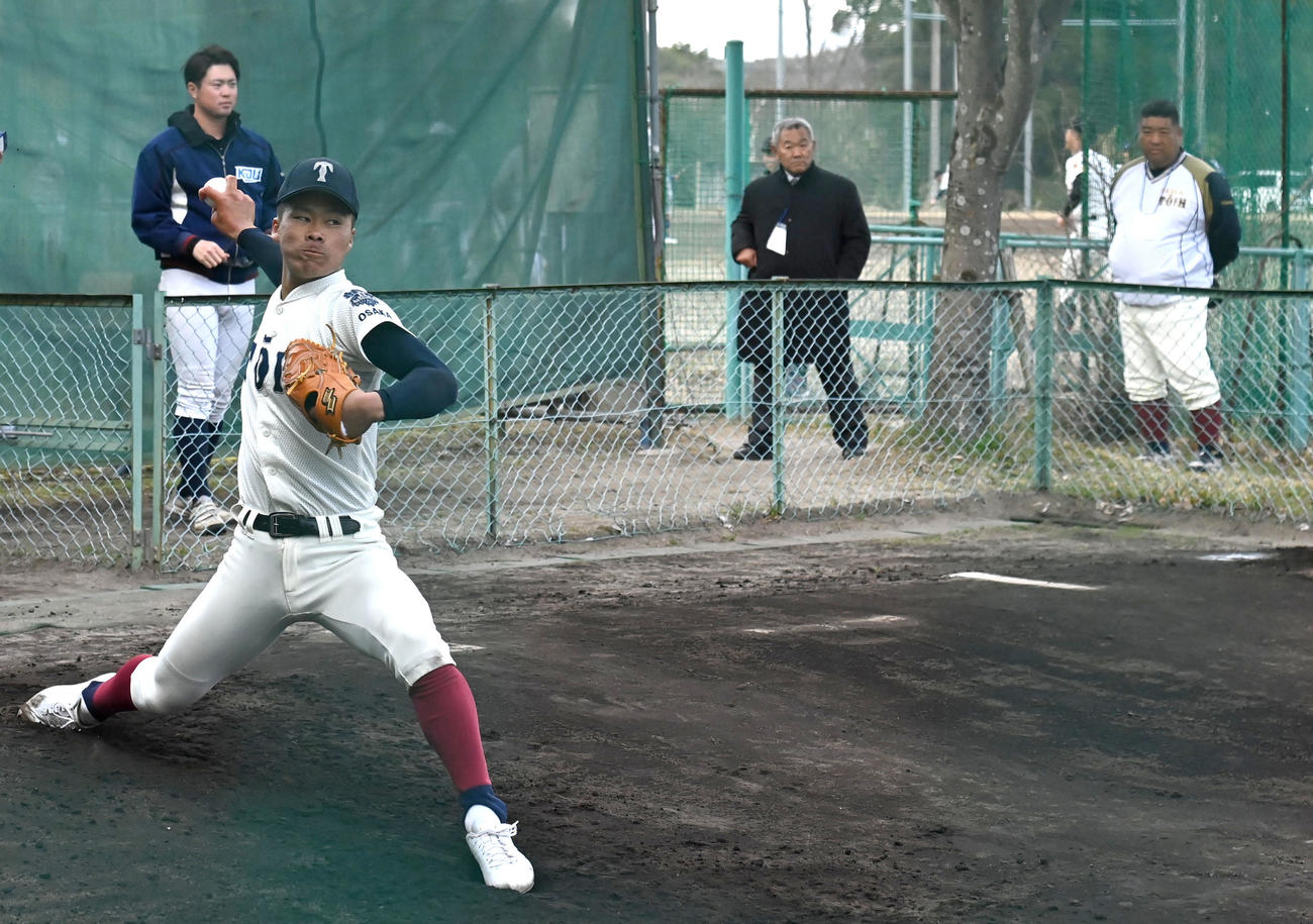大阪桐蔭の西谷監督（右）が見守る中ブルペンで投球練習をする大阪桐蔭の中野（撮影・石井愛子）