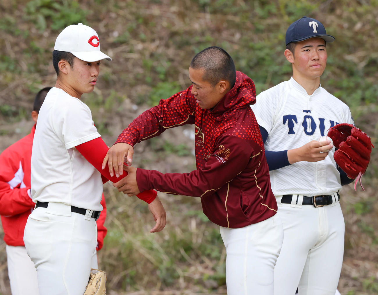 U18強化合宿で智弁和歌山・渡辺（左）の腕をさわる大阪桐蔭・中野。右は大阪桐蔭・森（撮影・上山淳一）