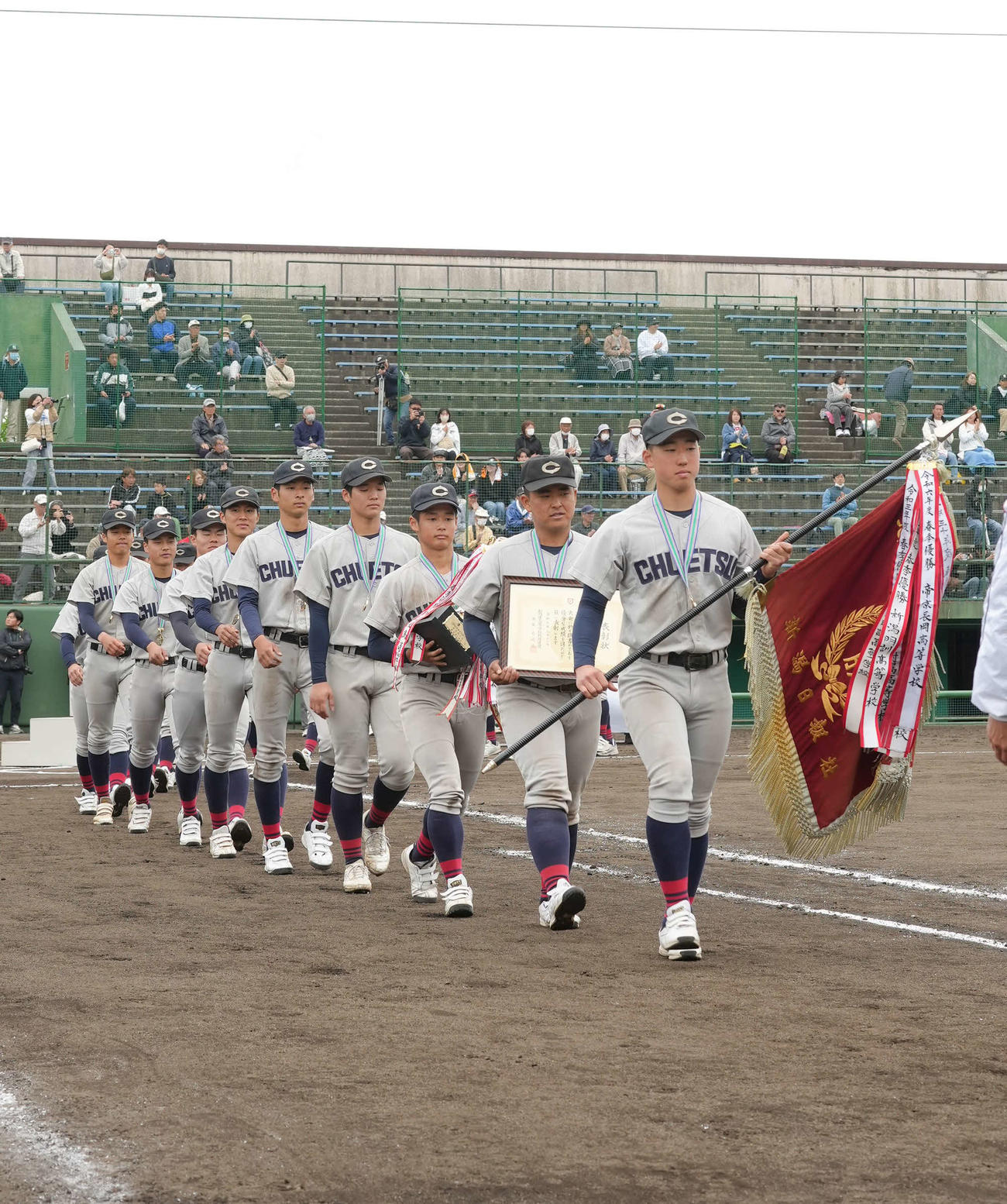 閉会式で優勝旗を先頭に行進をする中越ナイン