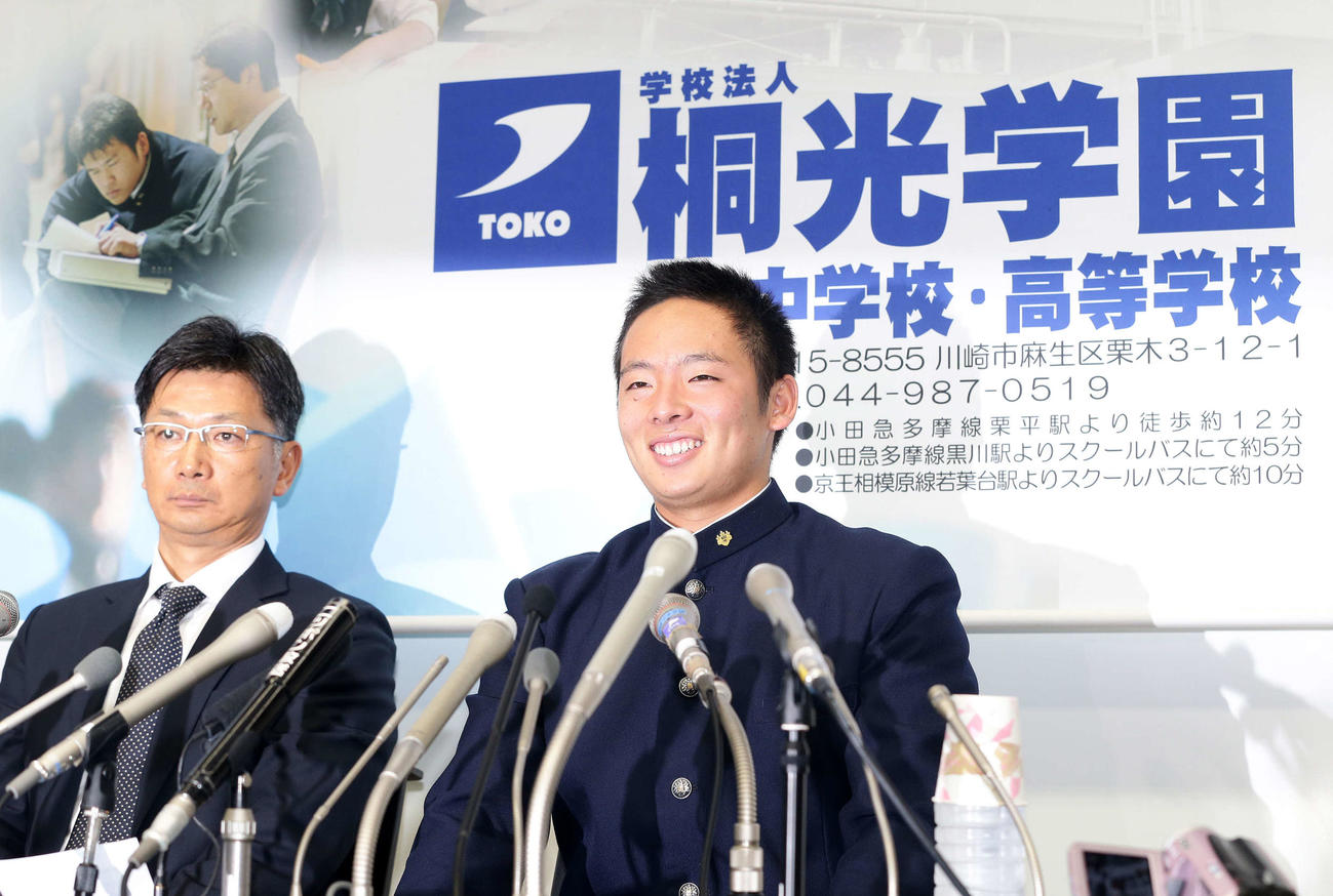 13年10月24日　楽天から1位指名を受け会見を行い笑顔を見せる桐光学園・松井（右）。左は野呂監督