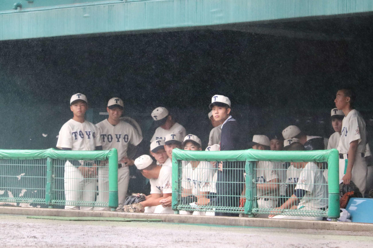 試合前、雨脚が強くなりベンチで待機する東洋大姫路ナイン