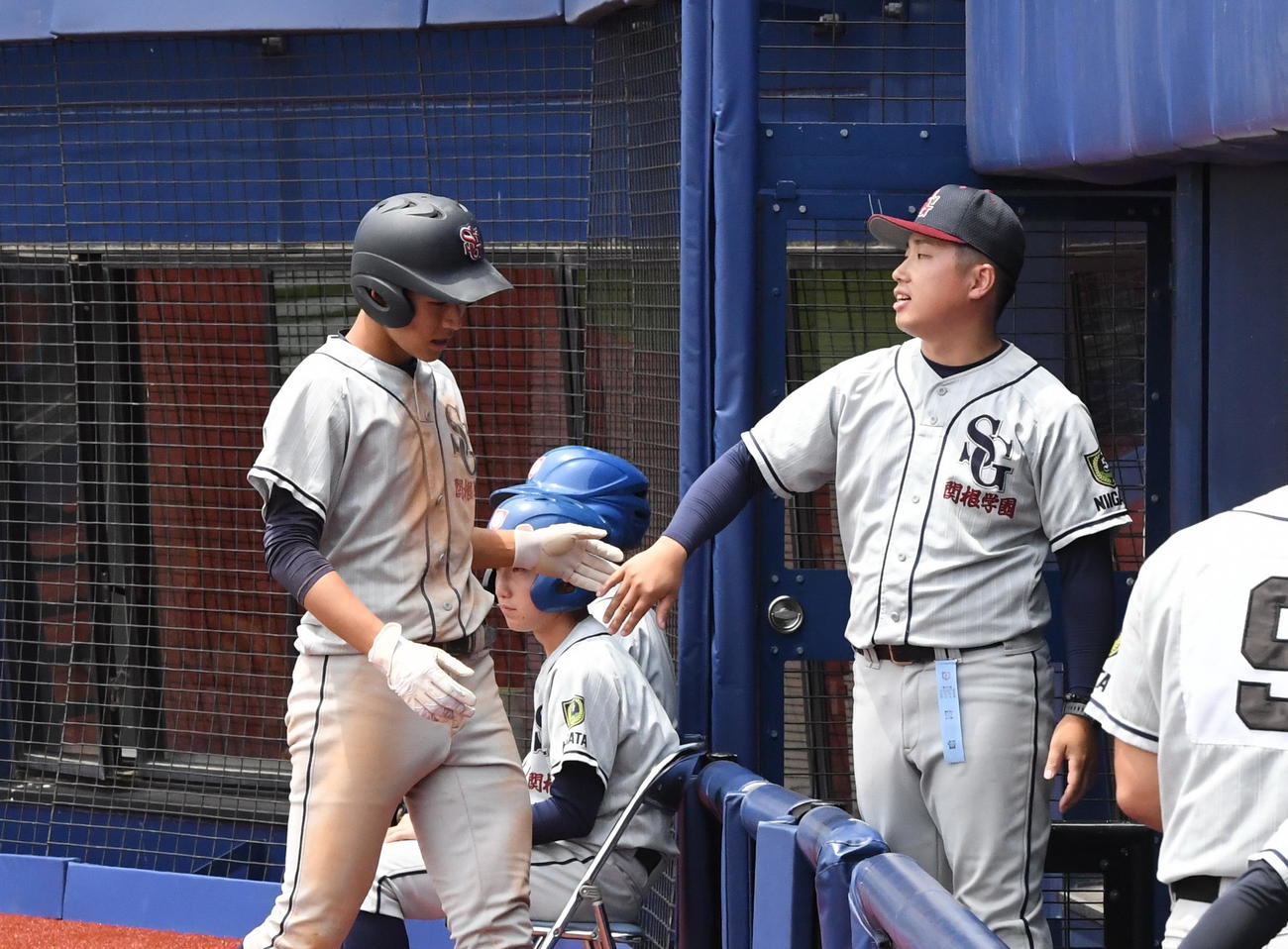 長野商対関根学園　2－6の9回裏無死、右越えに本塁打を放った関根学園・相馬隼（左）をベンチで迎える安川監督（撮影・小林忠）