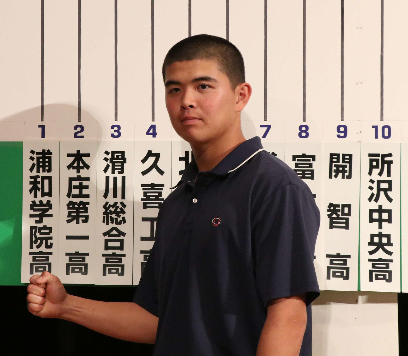 校名の札の前でガッツポーズをする浦和学院・西田主将（撮影・山本佳央）