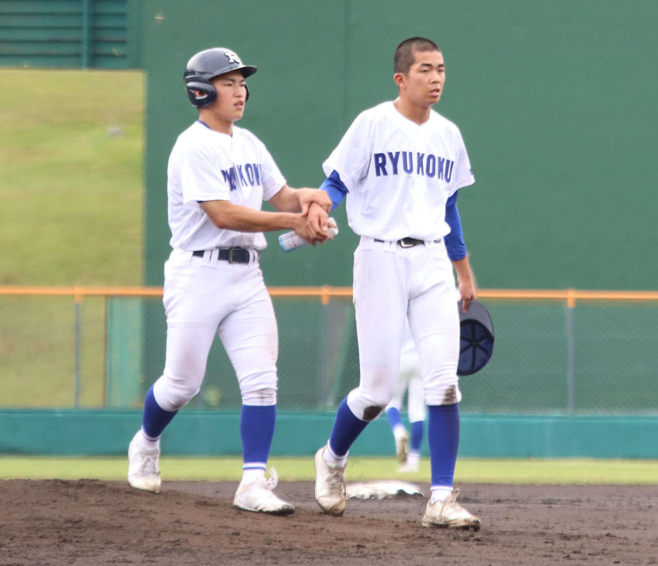 3回、右前腕に打球が当たり、治療のためベンチに向かう札幌龍谷学園の竹村（右）（撮影・保坂果那）