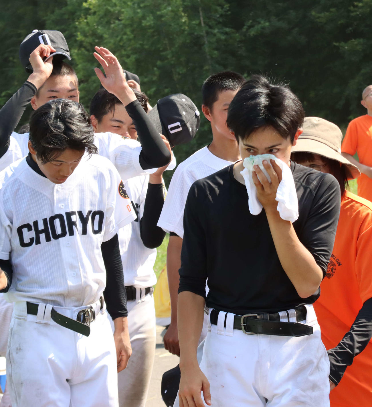 負傷した鼻を押さえて球場から引き揚げる小樽潮陵の村岡主将（手前右）（撮影・保坂果那）