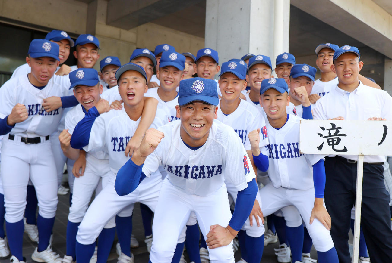 滝川の新井主将（手前）はナインらと笑顔で写真に納まる（撮影・上山淳一）