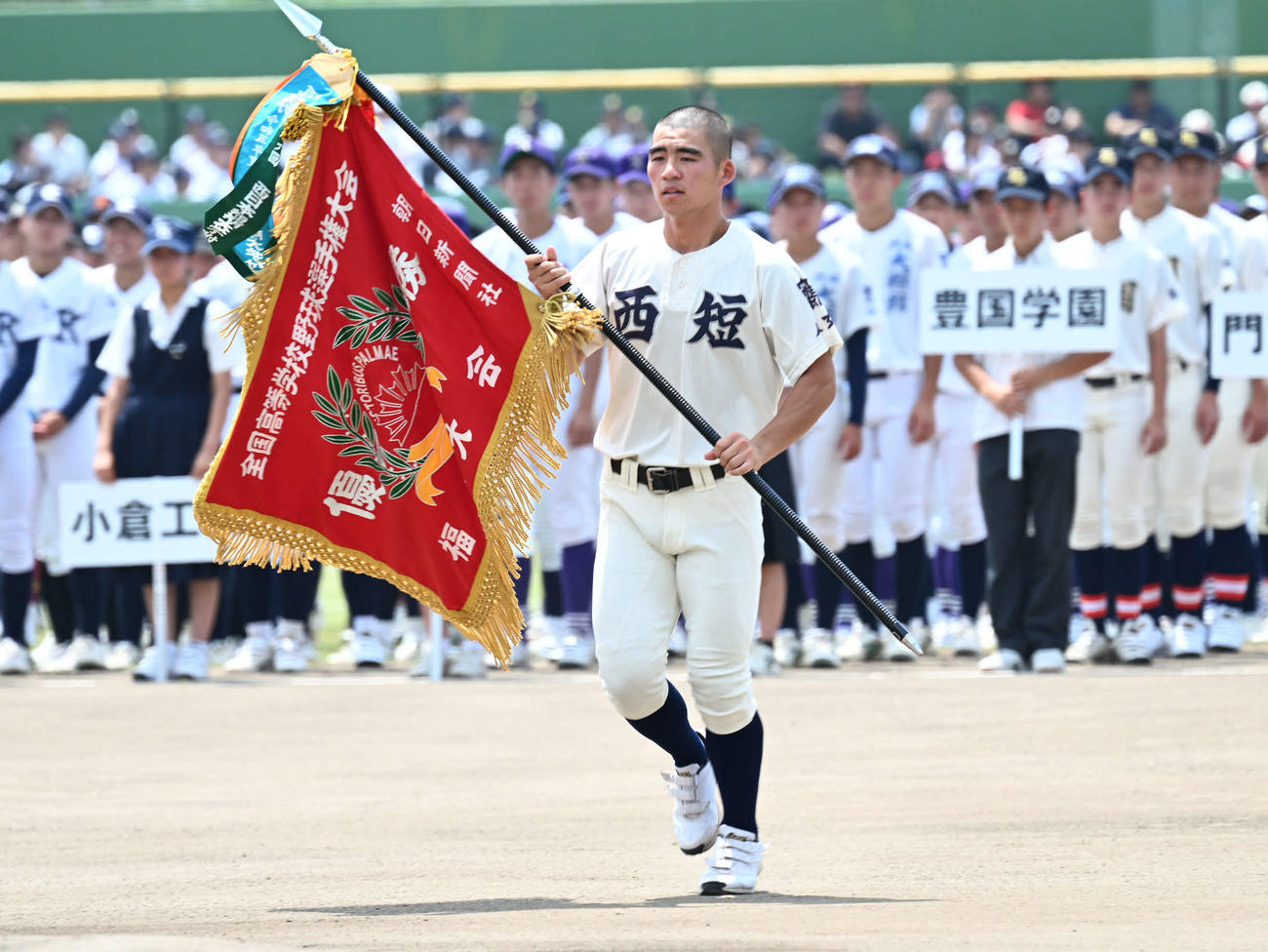 高校野球福岡大会の開会式で優勝旗返還を行う西日本短大付・小川主将（撮影・林敢治）