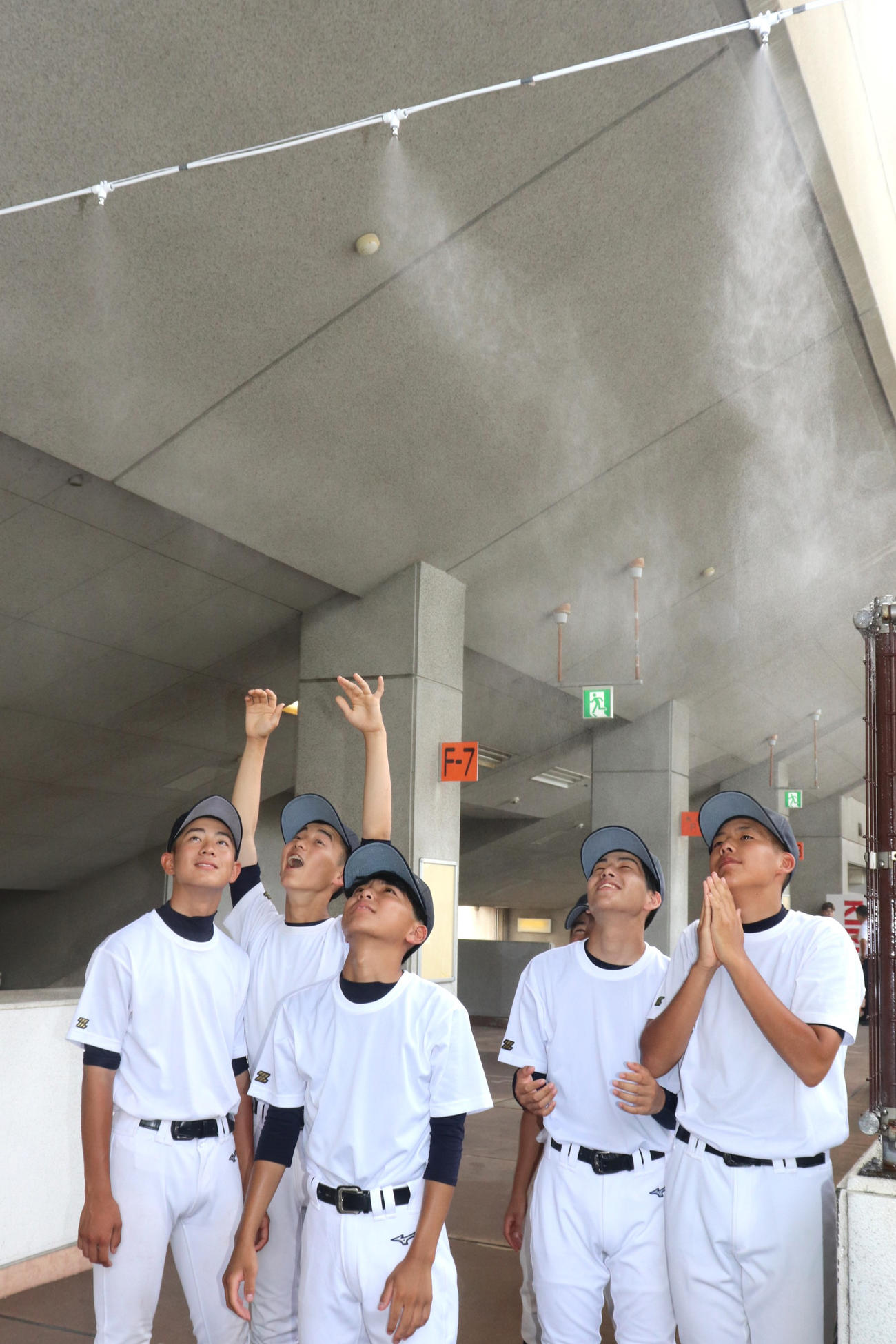 京都大会・開会式　わかさスタジアム京都で今夏新たに設置された霧状のミストで涼む、峰山の1年生部員たち（撮影・中島麗）