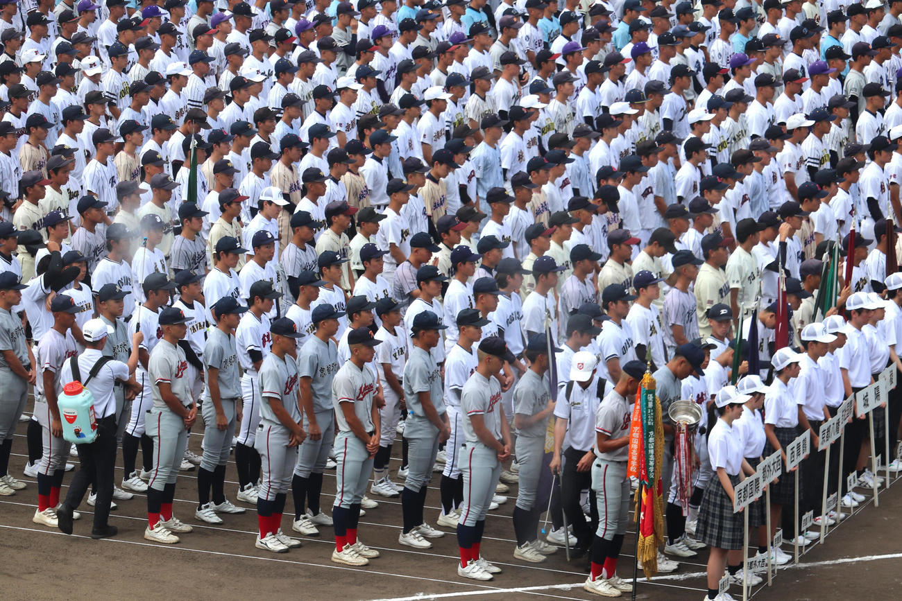 京都大会・開会式　府高野連スタッフのミスト隊によるミストで涼む、グラウンドに並ぶ選手たち（撮影・中島麗）