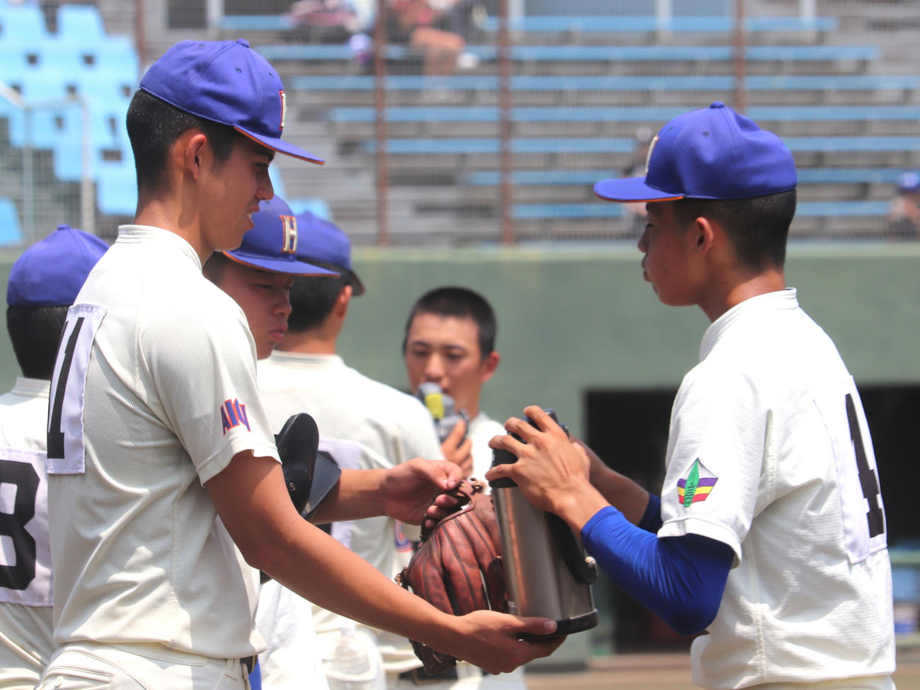 愛知大会2回戦　愛知総合工科対誉　4回の攻撃前に誉の原口に水筒を差し出す、背番号11のモレチ（撮影・中島麗）