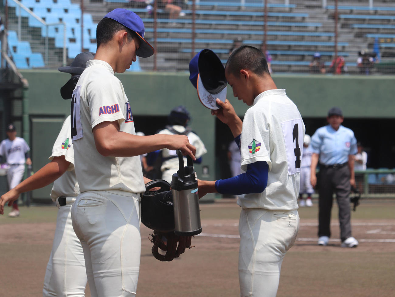 愛知大会2回戦　愛知総合工科対誉　4回の攻撃前に誉の原口に水筒を差し出す、背番号11のモレチ（撮影・中島麗）