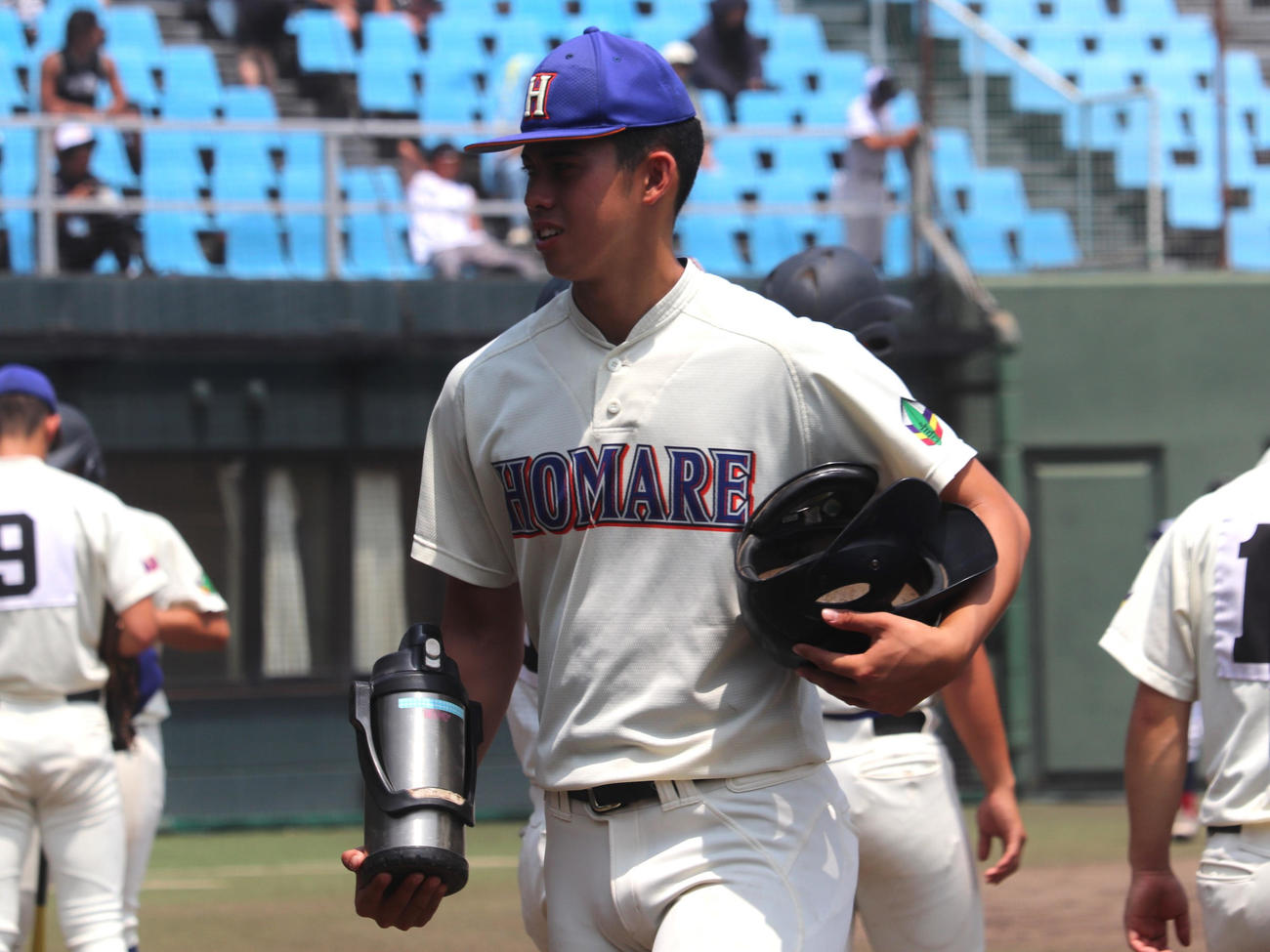 愛知大会2回戦　愛知総合工科対誉　4回の攻撃前にチームメートの水筒を運ぶ、背番号11のモレチ（撮影・中島麗）