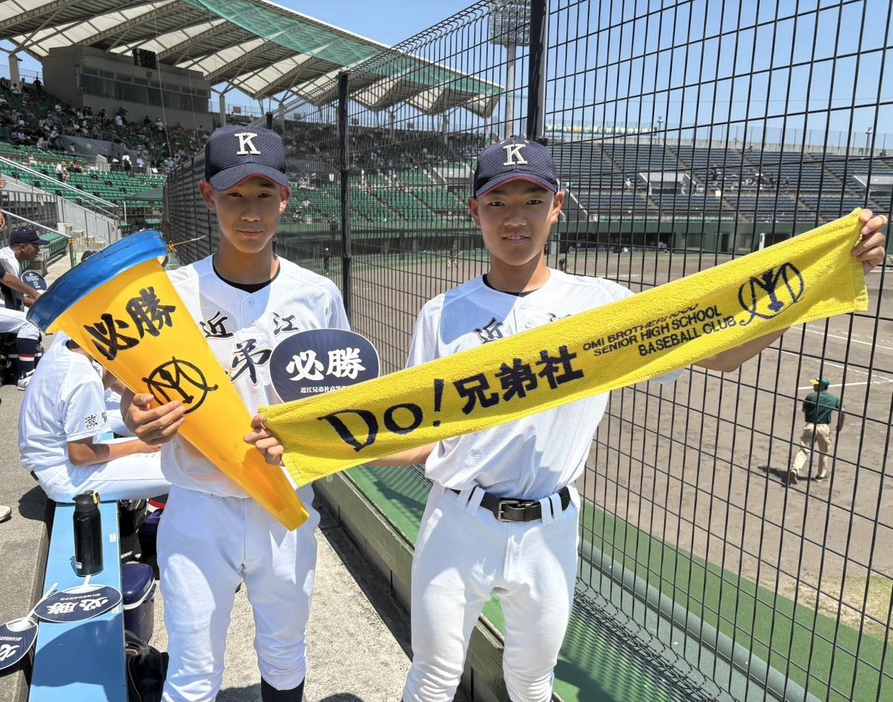 近江兄弟社の部員が学校カラーの黄色いビッグメガホンとタオルを手に写真におさまる（撮影・林亮佑）