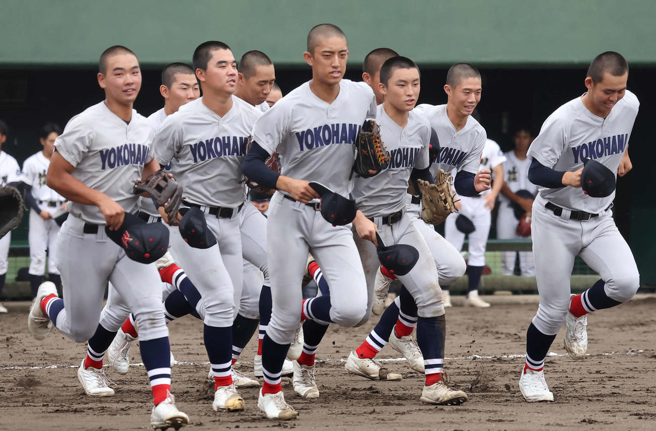 横浜対荏田　初戦に勝利して応援席に向かって駆け出す横浜ナイン。右から2人目はこの試合に先発した1年生の小林（撮影・丹羽敏通）
