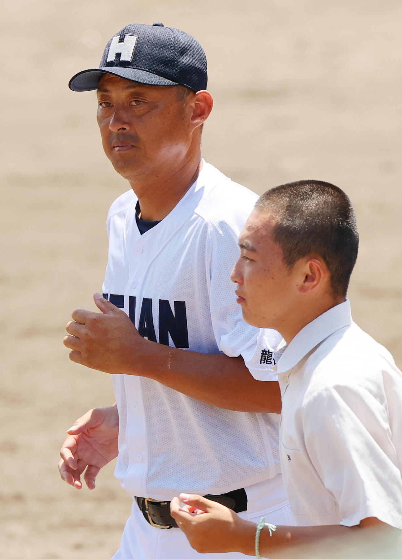 京産大付対龍谷大平安　京産大付に勝利した龍谷大平安の川口監督（左）は応援団にあいさつへ向かう（撮影・上山淳一）