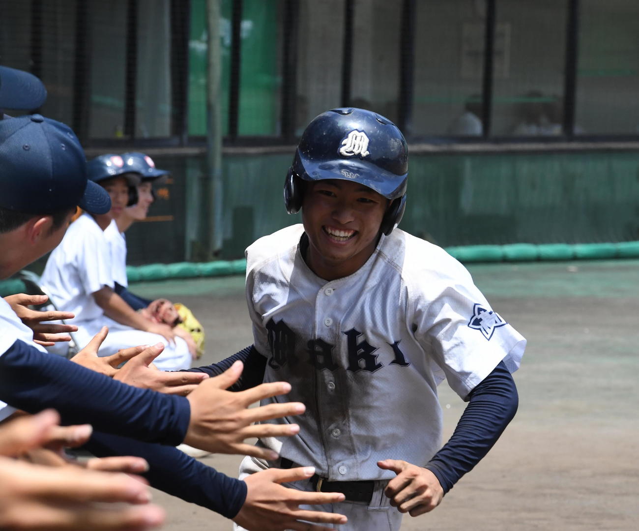 新潟西対巻　3－3の8回裏、一塁から一気に生還した巻・玉橋（右）がベンチの仲間とタッチ（撮影・小林忠）