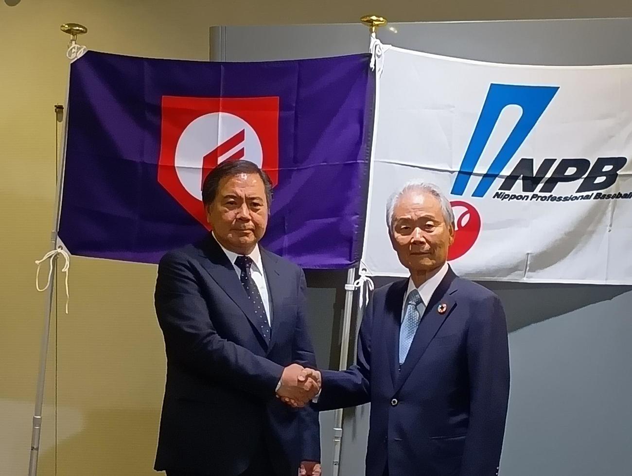 日本高野連とNPBによる野球振興事業が決まり、高野連の宝馨会長（左）とNPB榊原定征コミッショナーは握手を交わす